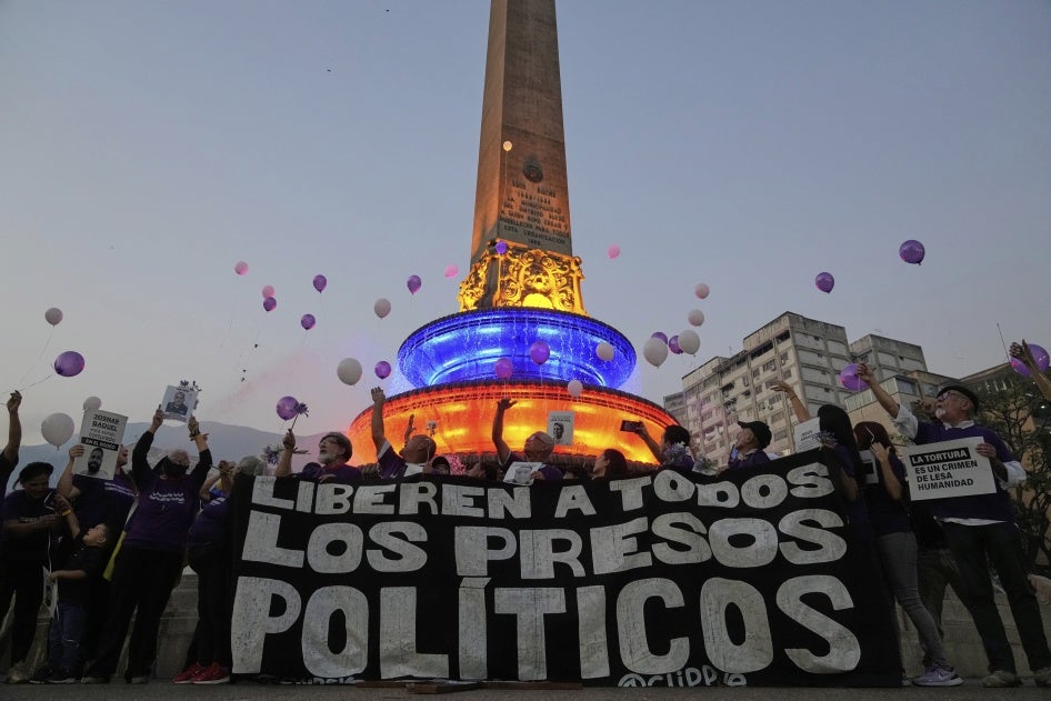 Des proches de prisonniers politiques vénézuéliens et des activistes lâchaient dans le ciel des ballons symbolisant la liberté, derrière une bannière avec le message « Libérer tous les prisonniers politiques », lors d’un rassemblement à Caracas, au Venezuela, le 14 avril 2025. 