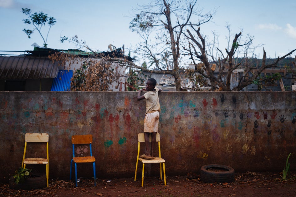 Un garçon regarde par-dessus la clôture d'une école dans la commune de Bouyouni à Mayotte, département français dans l'océan Indien, le 19 décembre 2024, après le passage du cyclone Chido.
