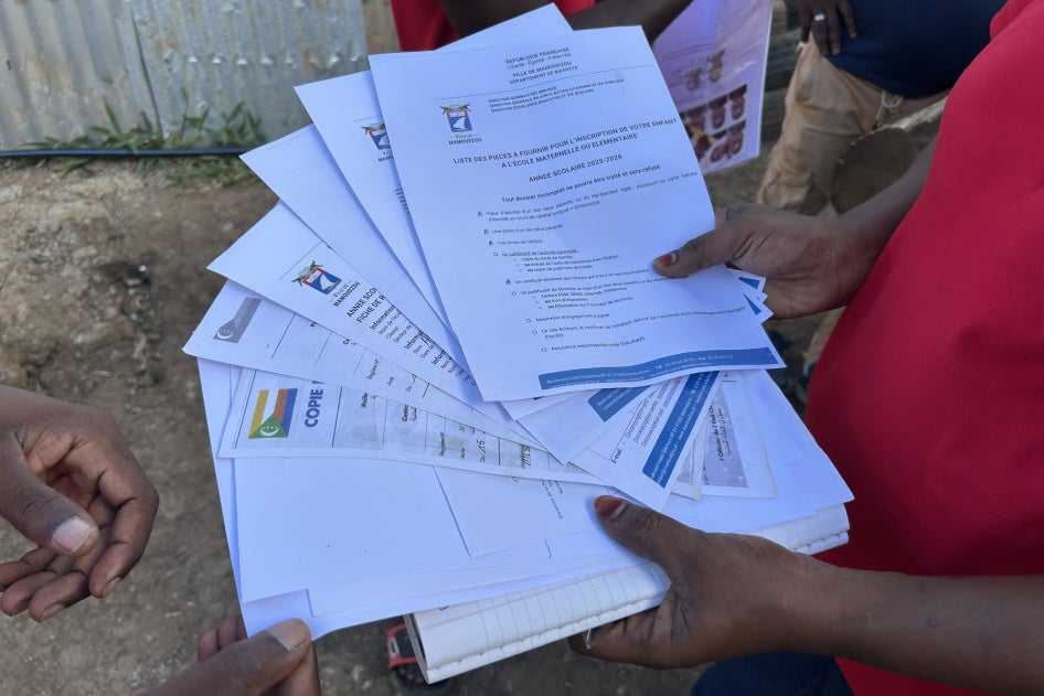 A volunteer reviews the documents a parent has gathered to register his child in elementary schooll