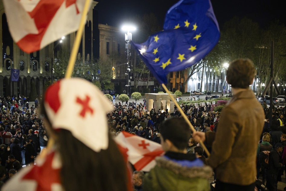 Des manifestants brandissaient des drapeaux de la Géorgie et de l’Union européenne devant le Parlement à Tbilissi, en Géorgie, dans la soirée du 8 avril 2025. 