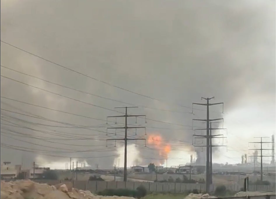 Une image extraite d'une vidéo filmée depuis un véhicule sur la route 96, dans le sud de l’Iran, le 18 mars 2026, suite à une frappe israélienne contre le gisement gazier de South Pars. On y voit de très épais nuages de fumée suite aux incendies provoqués, notamment celui de la quatrième raffinerie. Vidéo publiée par Vahid Online (https://x.com/Vahid/status/2034333984503529778), géolocalisée par FactNameh (https://x.com/factnameh/status/2034415274430988685/photo/1), corroborée par Human Rights Watch.