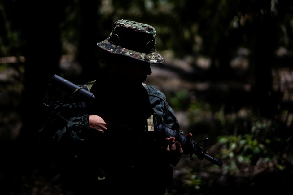 An unidentifiable child soldier holding a gun