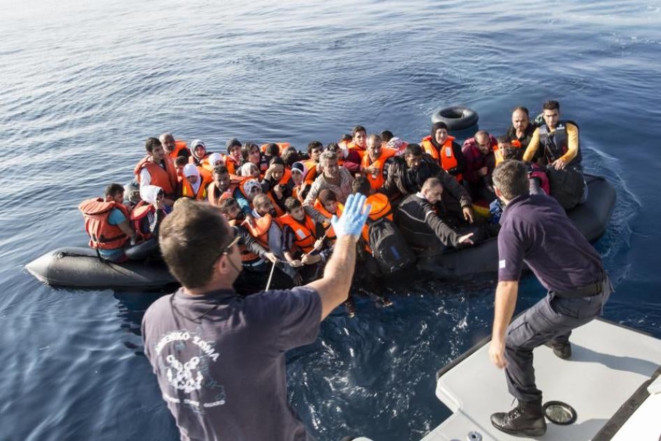 Members of the Hellenic Coast Guard rescue migrants and asylum seekers from an overcrowded rubber dinghy found drifting in the sea off Lesbos island in Greece.  October 4, 2015.
