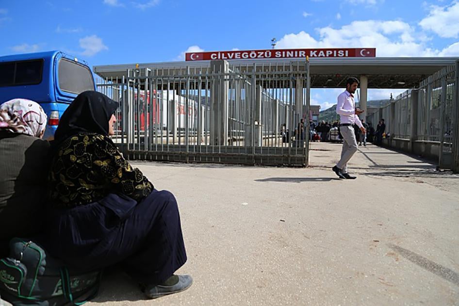 Deux femmes assises près du poste-frontière de Cilvegözü dans le sud-ouest de la Turquie, jouxtant la région d'Alep en Syrie, le 3 mars 2015. Ce point de passage a été fréquemment utilisé par des Syriens fuyant leur pays, mais aussi par la suite, par des 