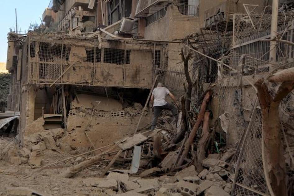 A man walks on debris in the Palestinian Yarmouk refugee camp, on the southern outskirts of Damascus, June 3, 2015. 