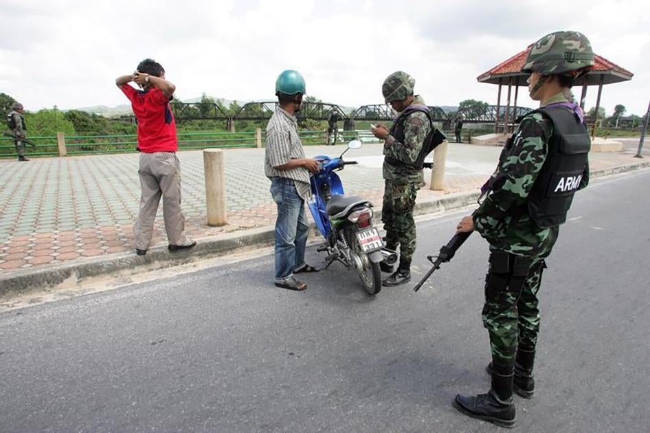 Thai soldiers check documents of local residents as they man a checkpoint in the central Yala province, south of Bangkok on January 25, 2010. 