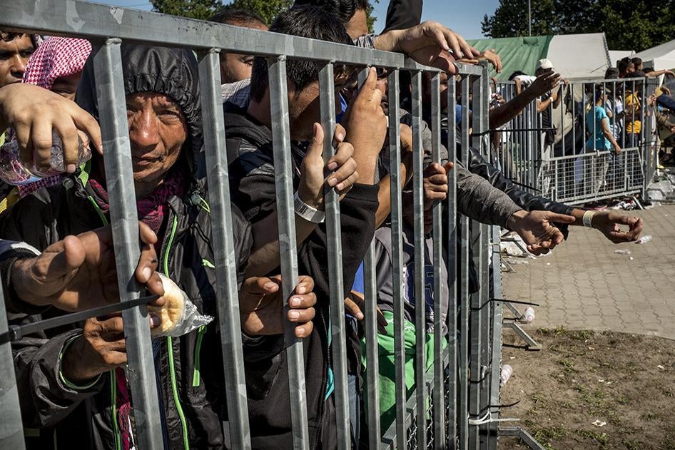 Беженцы за металлической оградой в миграционном лагере «Хангар 1» в городе Рожке, Венгрия, 9 сентября 2015 года.