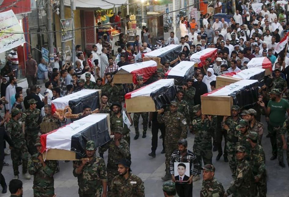  Members of Shi'ite group Asa'ib Ahl al-Haq carry the remains of Shi'ite soldiers from Camp Speicher, who were killed last summer by Islamic State militants, during the funeral ceremony in Najaf, south of Baghdad on July 1, 2015. 