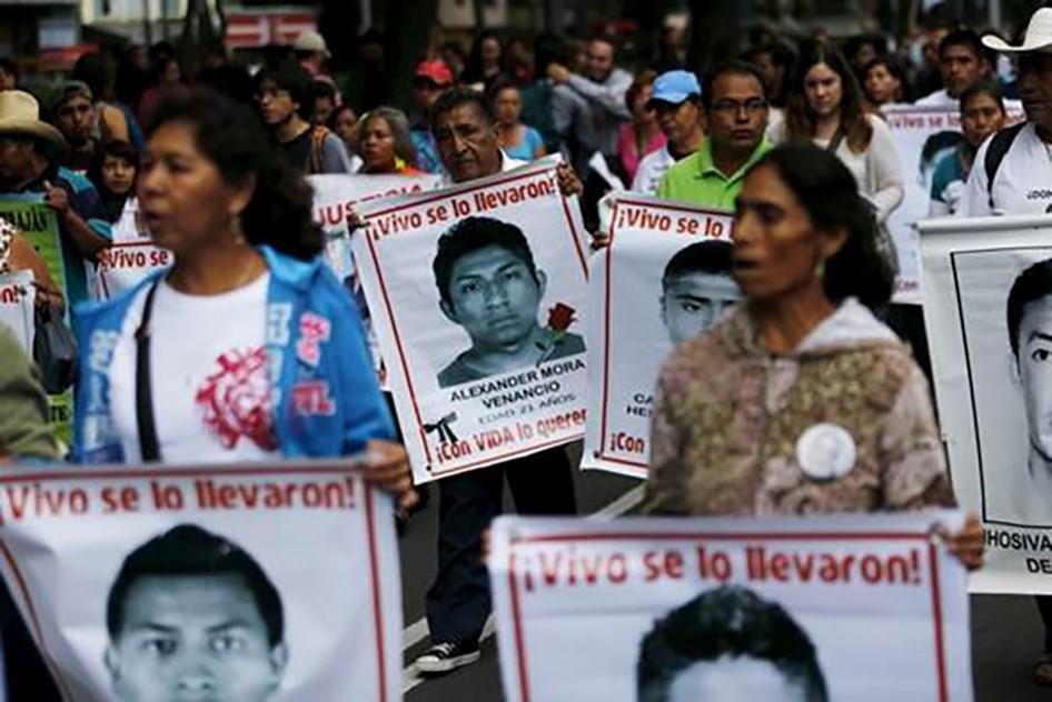 Familiares de víctimas llevan fotos de algunos de los 43 estudiantes normalistas desaparecidos, durante una protesta en el décimo primero mes luego de su desaparición, en México D.F., México, el 26 de agosto de 2015. 
