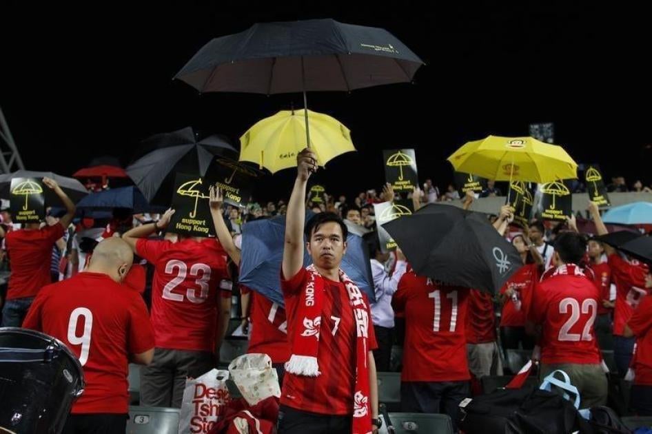 2014年10月14日， 香港和阿根廷在香港的国际足球友谊赛播放中国国歌时， 佔中支持者撑起雨伞。