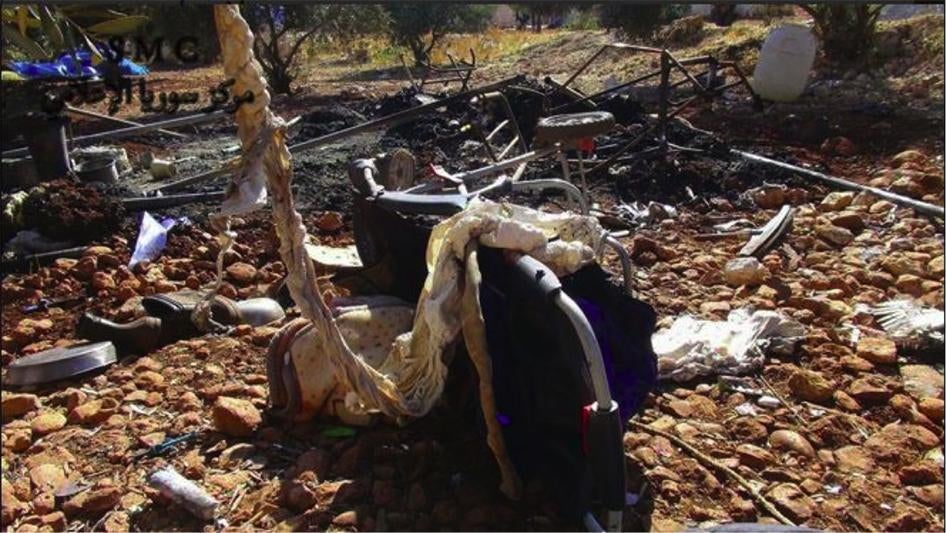 Детская коляска у сгоревшей палатки в лагере вынужденных переселенцев близ селения Эн-Накир, провинция Хама, после кассетного удара 7 октября 2015 г., в результате которого погибли по меньшей мере трое гражданских лиц.