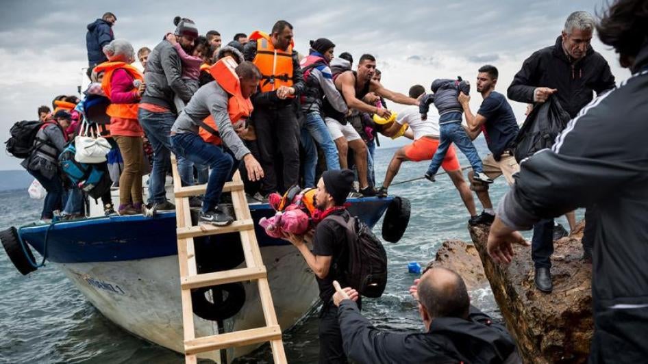 Asylum seekers and migrants descend from a large fishing vessel used to transport them from Turkey to the Greek island of Lesbos. October 11, 2015. 