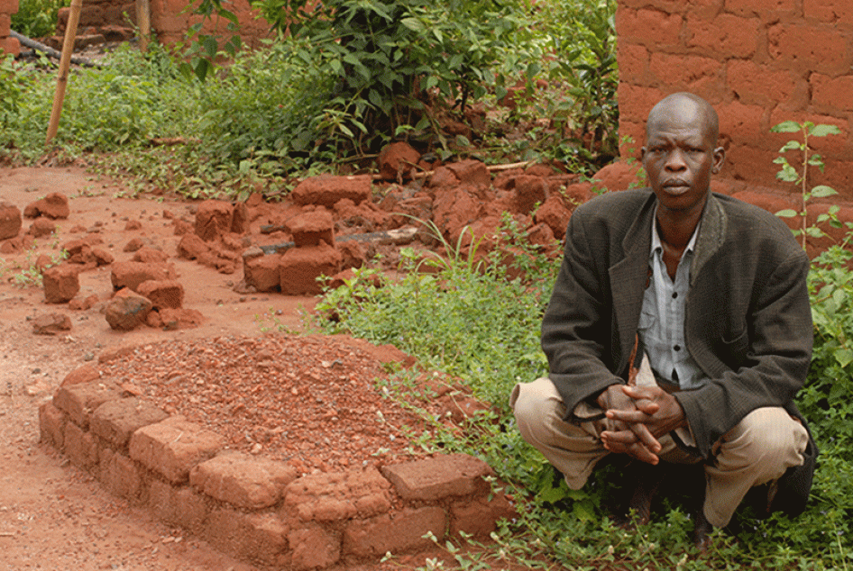 Jean Baptiste Nguondija, un habitant de Ngbada, en République centrafricaine, accroupi près par la tombe de sa fille Nathana Poura, devenue victime des violences sectaires à l’âge de 10 ans. Nguondija a perdu cinq enfants depuis le début du conflit en 201