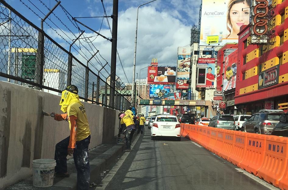 Workers from the Metropolitan Manila Development Authority whitewash the walls of the metro line along EDSA, Manila's main highway, in time for the APEC Summit that begins on November 16, 2015. November 13, 2015. 