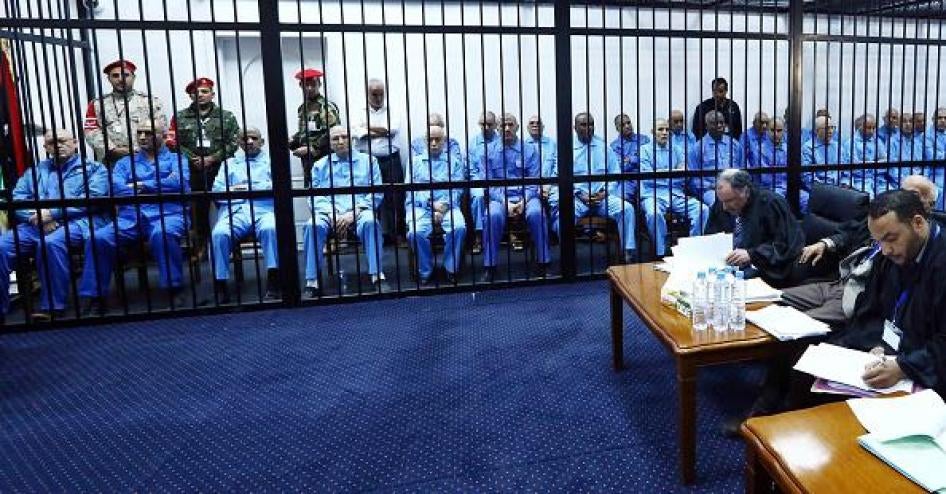 رئيس الاستخبارات الليبية السابق عبد الله السنوسي يجلس خلق القضبان مع آخرين مشتبه بهم خلال محاكمتهم في قاعة محكمة في طرابلس، ليبيا، يوم 16 نوفمبر/تشرين الثاني، 2014. 