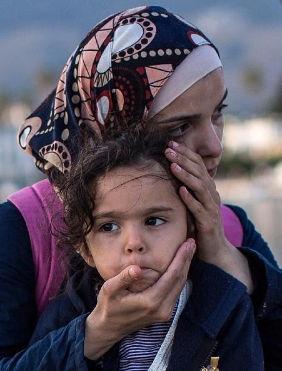  یک زن سوری دخترش را در کناره اسکله در آغوش می کشد بعد از اینکه گارد ساحلی آنها را در ژوئن ۲۰۱۴ در حالی که به ساحل کاوس واقع در یونان وارد می شدند، پیدا و تا لنگرگاه همراهی کرد.