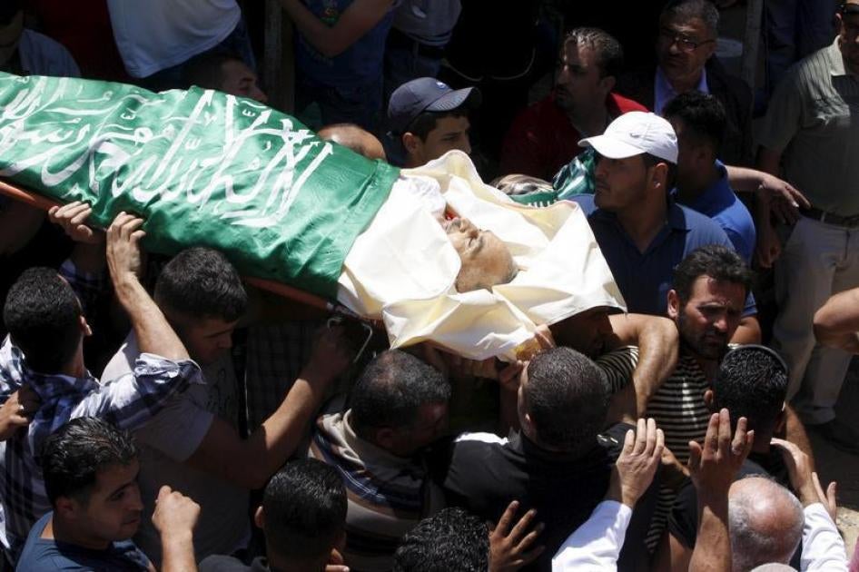 Mourners carry the body of Palestinian man Falah Abu Marya, 53, during his funeral in the village of Beit Ummar near the West Bank city of Hebron July 23, 2015