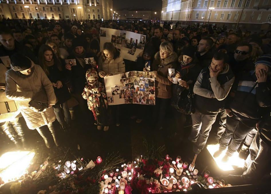 Люди приносят фото жертв российского самолета, потерпевшего крушение в Египте, в результате которого 224 человека погибли. Дворцовая площать Санкт-Петербурга, 1 ноября 2015 г.