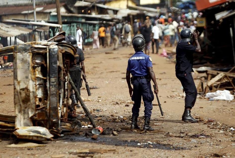 Les forces de sécurité guinéennes tentent de disperser la foule au carrefour Matoto, à Conakry, en Guinée, le 10 octobre 2015. Des magasins y ont été incendiés et pillés à la suite de heurts la veille entre des partisans du président Alpha Condé et de son