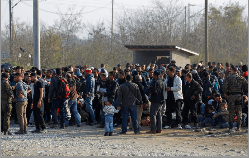 Migrants stand in line to enter a registration camp after crossing the border from Greece in Gevgelija.