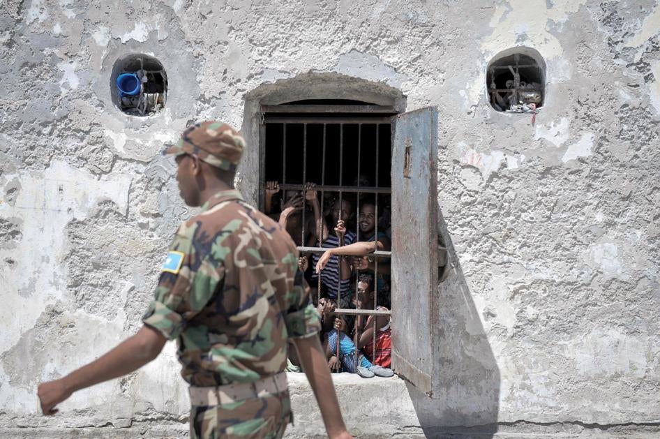 Prisoners at Mogadishu Central Prison watch as a guard walks pass their cell in December 2013. Most of the military court’s hearings in Mogadishu take place inside the prison, which limits access to hearings for relatives and independent monitors.