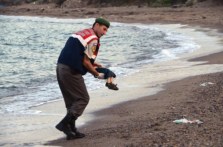 ضابط من الشرطة شبه العسكرية يحمل جثة هامدة لطفل مهاجر بعدما لقي عدد من المهاجرين حتفهم عندما انقلب بهم قارب كان يقلهم بالقرب من منتجع بودروم التركي.