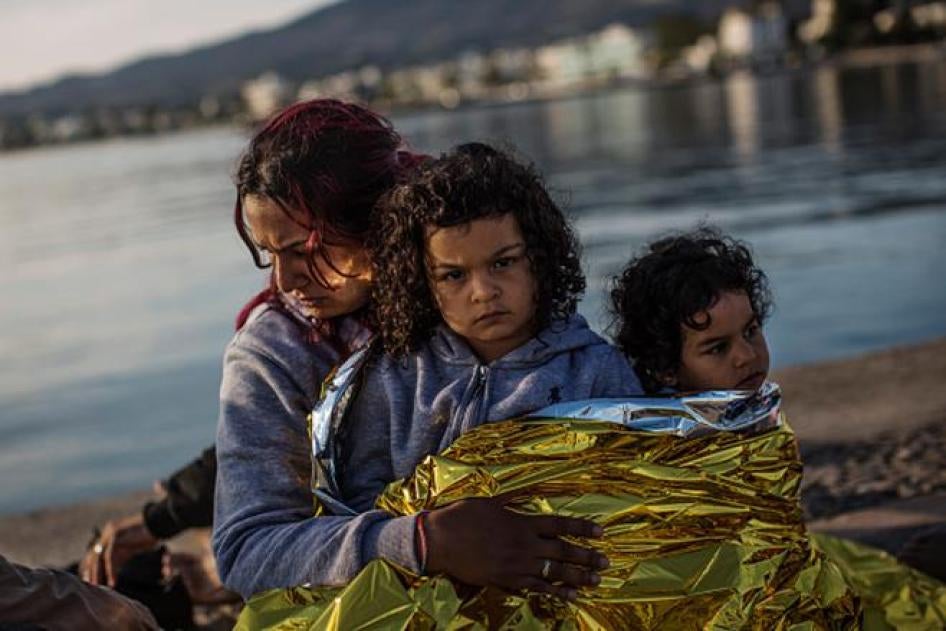Trois membres d’une famille syrienne assis près du quai du port de Kos, en Grèce, peu après avoir été recueillis par des garde-côtes qui ont aperçu leur embarcation au large des côtes grecques, le 4 juin 2015.