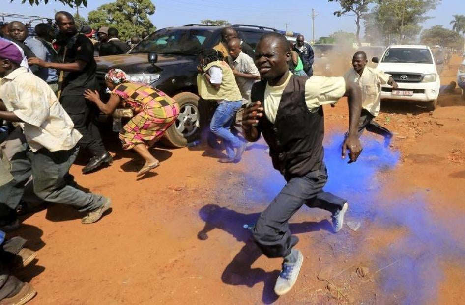 People gathered at a rally for Uganda's former Prime Minister Amama Mbabazi run from a colored teargas canister that police used to disperse a gathering in Jinja town in eastern Uganda, on September 10, 2015.