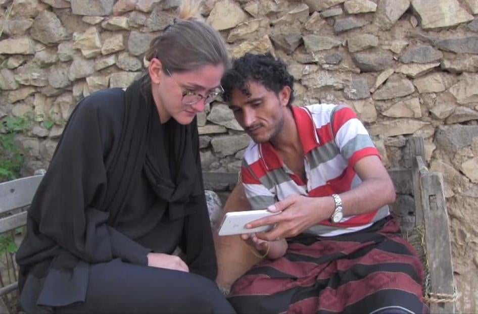 Walid al-Ibbi shows Human Rights Watch Researcher Belkis Wille video taken of his neighbors pulling the bodies of his family from the rubble of their home. 