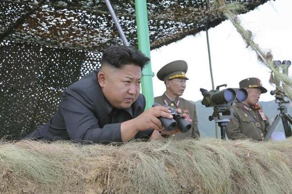 在这张朝鲜中央通讯社（朝中社）于2014年7月15日公布的照片中，朝鲜最高领导人金正恩持着望远镜指挥实弹演习。