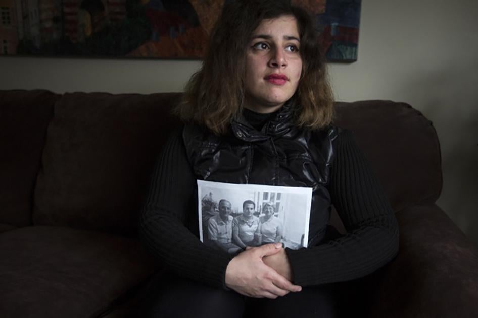 Refugiada recém-chegada da Síria, Sandy Khabbazeh, segura um retrato com uma foto de sua família que ficou para trás na Síria. Oakland, New Jersey. 22 de novembro de 2015.