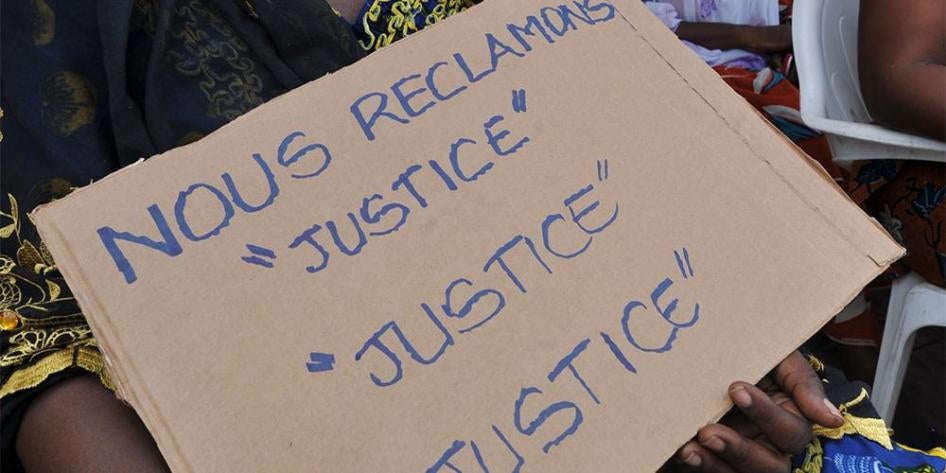 Pancarte tenue par une victime de la crise postélectorale de 2010-2011, lors d’une manifestation tenue à Abidjan le 28 février 2013, lors de l’audience de confirmation des charges à la Cour pénale internationale à La Haye contre l’ex-président ivoirien La