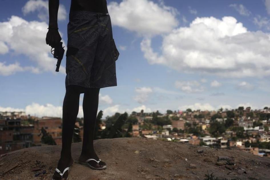 A 17-year-old Brazilian drug gang member poses with a gun atop a hill overlooking a slum in Salvador, Bahia State on April 11, 2013.