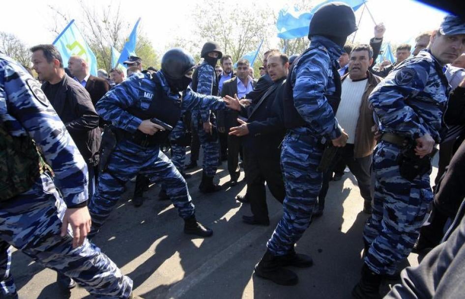 Russian security forces attempt to block Crimean Tatars trying to cross a checkpoint connecting Crimea to the rest of Ukraine, to attend a meeting. 