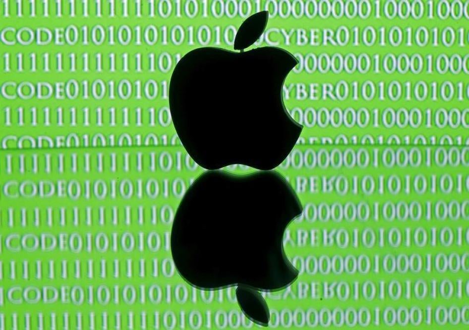 A 3D printed Apple logo is seen in front of a displayed cyber code in this illustration taken February 26, 2016.