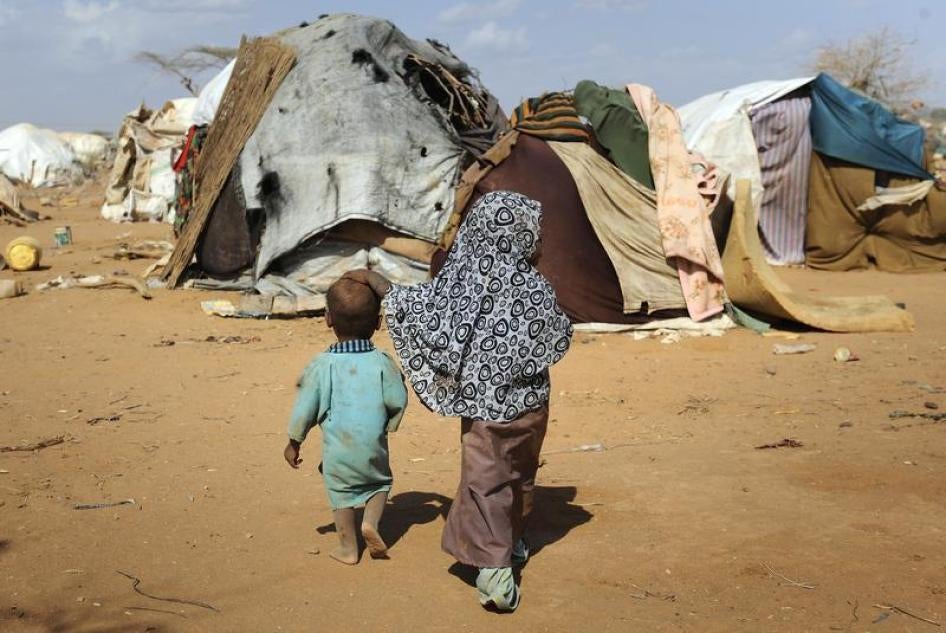 Children walk together amongst makeshift homes, or "tukuls", in the outskirts of Dagahaley settlement at Kenya's Dadaab Refugee Camp, August 31, 2011.