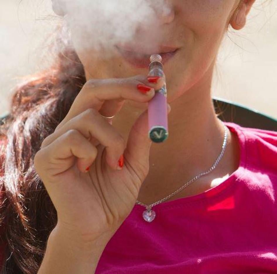 A young woman is seen smoking an e-cigarette..ar