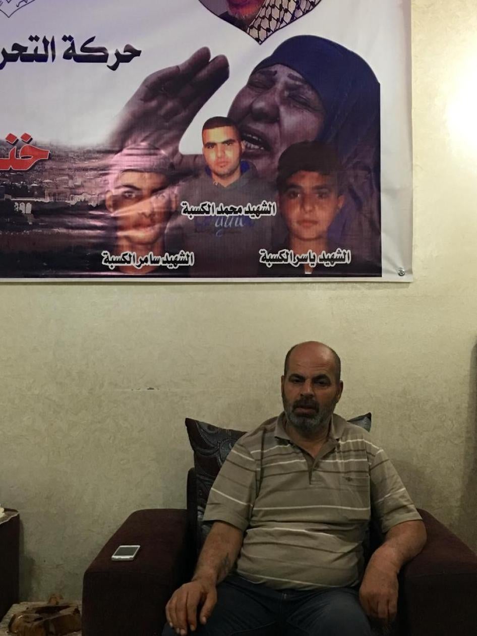 Sami al-Kasbeh sits under a poster of his three dead children, Qalandia Refugee Camp, Palestine, April 24, 2016.
