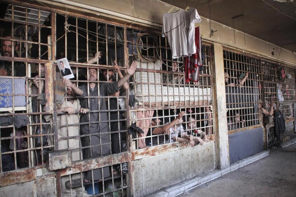 Inmates behind bars in Aleppo's main prison, May 2014. The Syrian government has detained children suspected of security-related offenses together with adults.