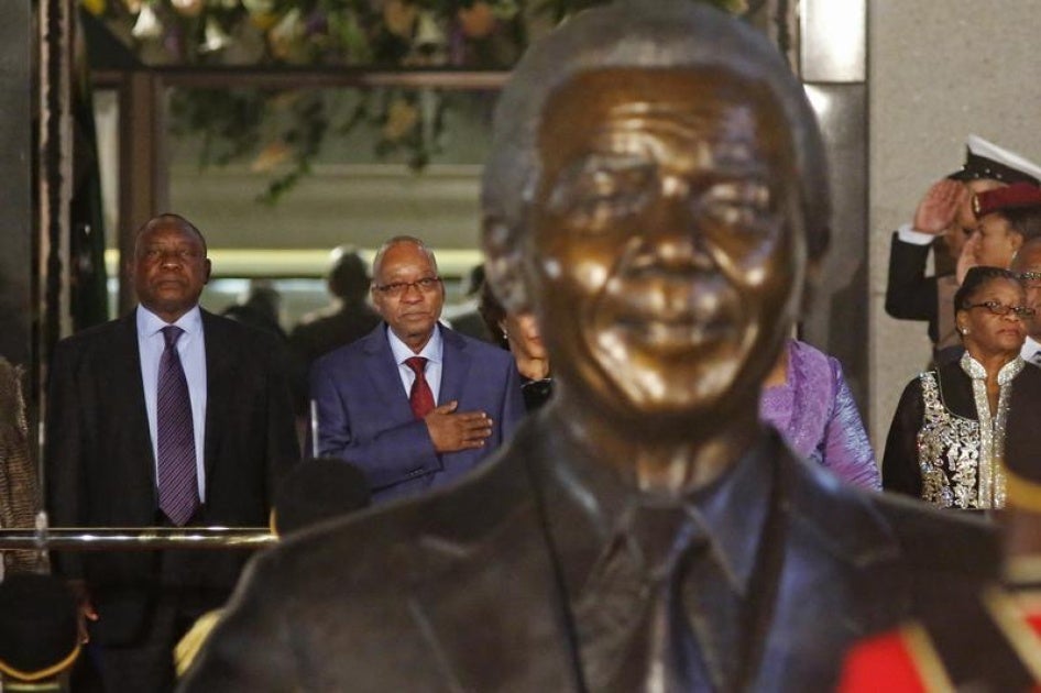 South African President Jacob Zuma (2nd L) stands behind a statue of former South African President Nelson Mandela outside Parliament in Cape Town June 17, 2014.