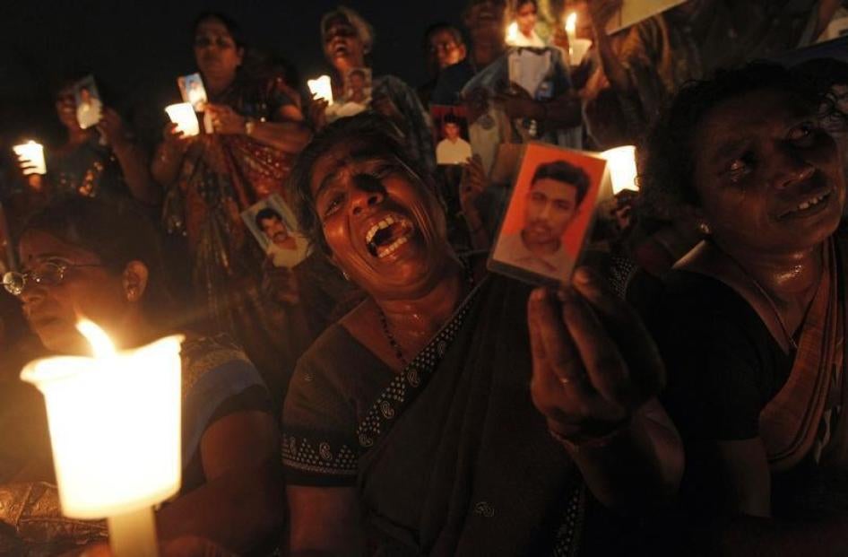 A Tamil woman cries as she holds up an image of her family member who disappeared during the civil war with the Liberation Tigers of Tamil Eelam (LTTE) at a vigil to commemorate the international day of the disappeared in Colombo August 30, 2013.