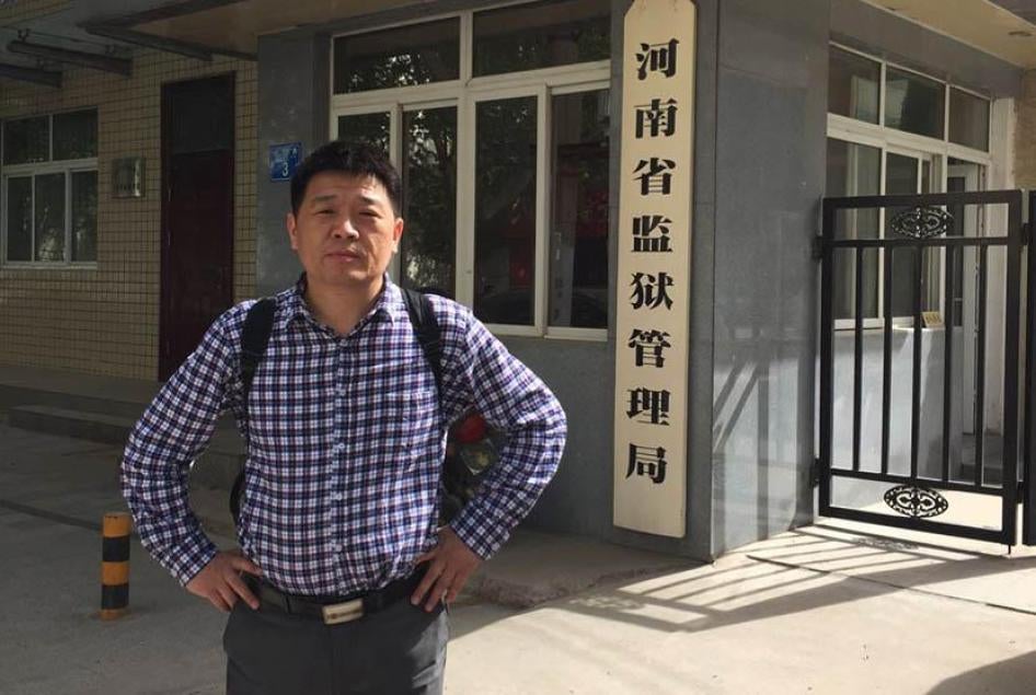 Li Jinxing poses at the entrance of the Bureau of Prison Administration, Zhengzhou, Henan province. 
