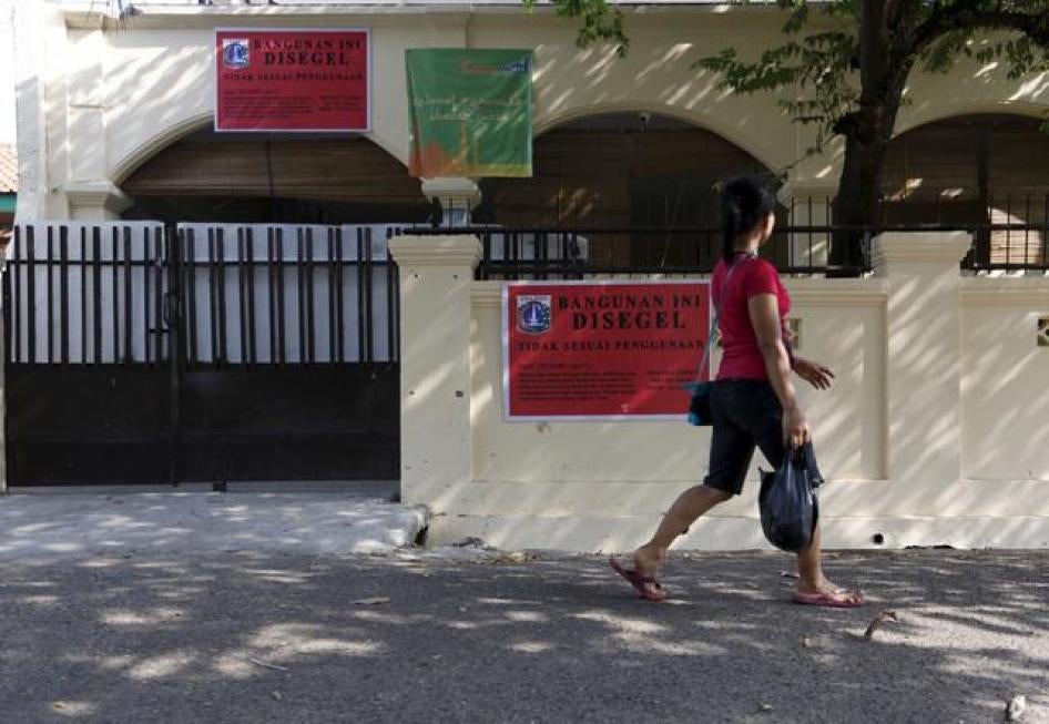 A woman walks by an Ahmadiyah mosque that was closed by government authorities in South Jakarta, Indonesia.