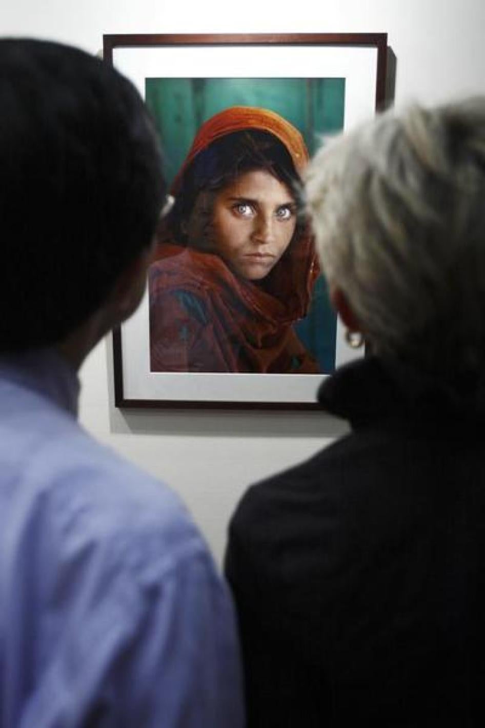 Visitors look at the "Afghan Girl" photo during U.S. photographer Steve McCurry's exhibition at the Asian Civilisation Museum in Singapore June 26, 2009.