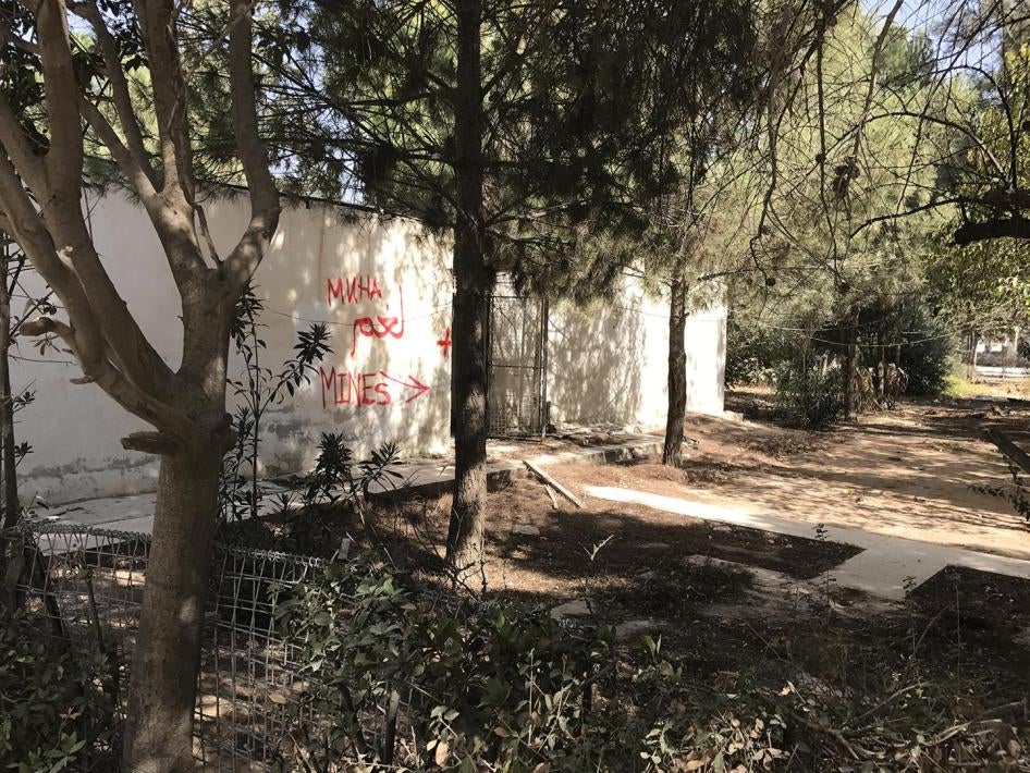 Writing on the wall in the yard of the main hospital in Manbij, warning of the presence of mines. 