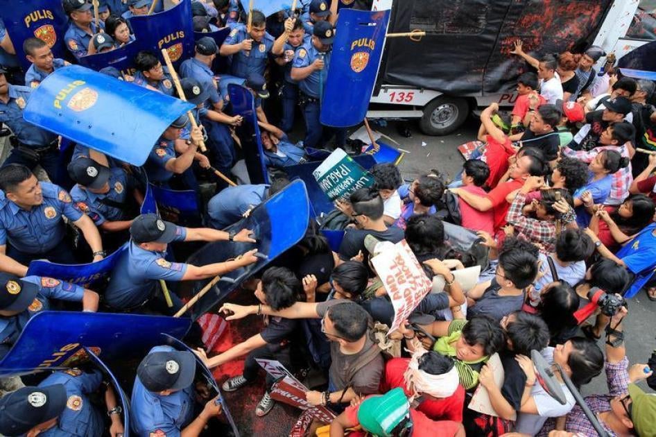 Various activists and indigenous people's groups clash with anti-riot policemen during an anti-U.S. protest in front of the U.S. Embassy in Metro Manila. 