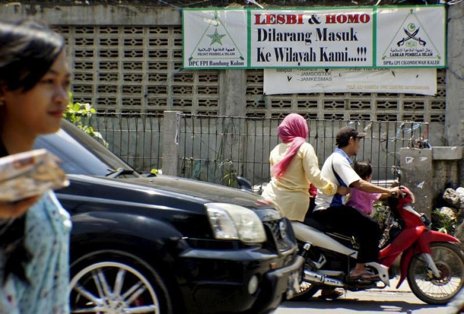机车骑士行经强硬派组织伊斯兰卫士阵线（Islamic Defenders Front）张挂的横幅，要求同性恋者离开印尼西爪哇省万隆市的齐贡德瓦区，2016年1月27日，安塔拉图片（Antara Foto）摄。横幅上写著：“本地区严禁同性恋”。