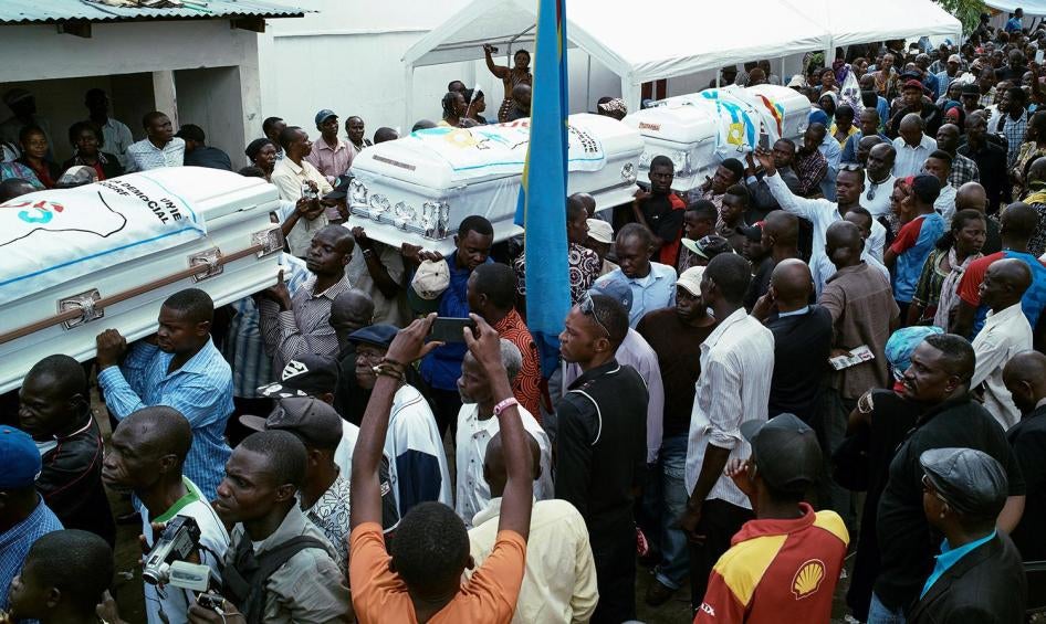 ​Des personnes portent les cercueils de manifestants tués au cours des manifestations des 19 et 20 septembre, lors d'une cérémonie organisée au siège du parti d'opposition Union pour la Démocratie et le Progrès Social (UDPS) à Kinshasa, en RD Congo, le 1e