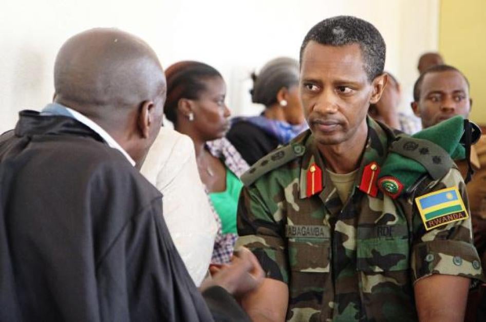 Le colonel Tom Byabagamba s'entretient avec son avocat avant une audience du tribunal militaire de Kigali le 29 août 2014.