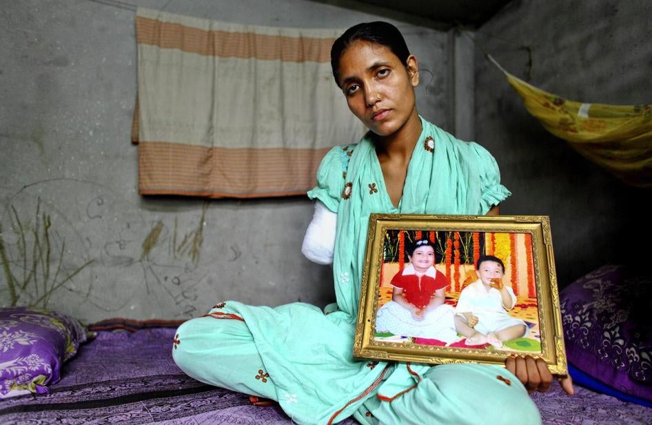 Mariam, a 27-year-¬old former textile worker and single mother, holds a picture of her two children. She lost her lower right arm when she was trapped in the collapsed Rana Plaza complex. © 2014 G.M.B. Akash/Panos